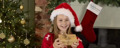 A banner showing a child holding a present with breakfast dishes sat on the table to advertise a Breakfast with Santa event at Chef & Brewer.