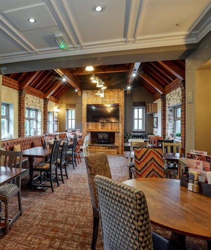Interior dining area of a pub with a TV and a fireplace.