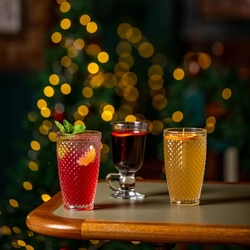 Three glasses of Christmas drinks sitting on a wooden table.