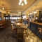 Interior dining area of a pub with a bar and a TV.