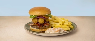 A Camembert Burger served on a plate with fries and coleslaw.