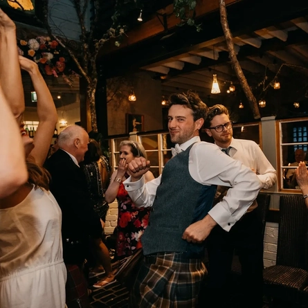 An interior shot of people dancing & celebrating a wedding at the Ubiquitous Chip in Glasgow.