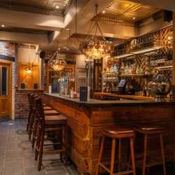 The interior bar with bar stools and seating area at the Ubiquitous Chip.