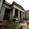 The exterior facade, signage, and beer garden seating area at the Old School House in Aberdeen, with large stone pillars, planter boxes, wooden picnic tables, and shade umbrellas.