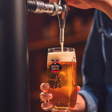 An image of a pint of Estrella Galicia being pouring behind the interior bar.