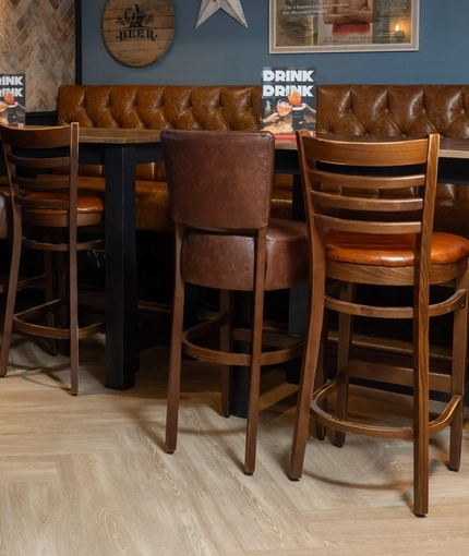 An interior restaurant seating area at the Cuckoo Oak, with an upholstered booth seat, and a TV on the wall.