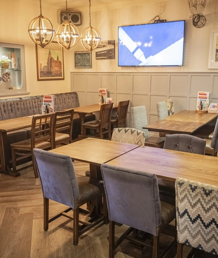 Interior dining area of a pub with a TV.