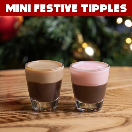 A banner advertising mini festive tipples at Hungry Horse venues, featuring two mini festive drinks in shot glasses which sit on a wooden table.