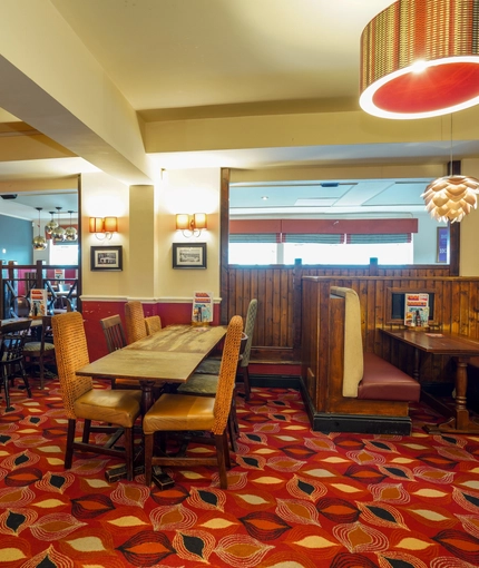 Interior dining area of a pub with a gambling machine.