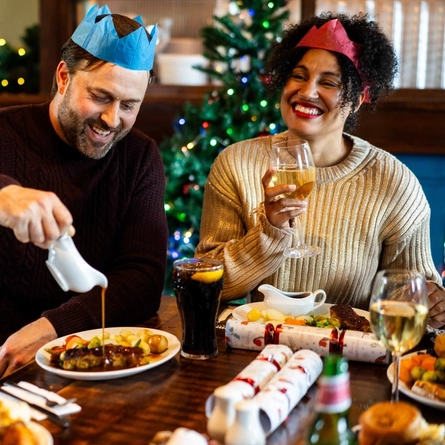 A man pouring gravy on his Christmas dinner