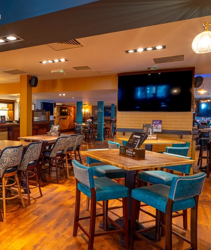 The bar and interior restaurant seating area at the Counting House, with TVs on the walls.