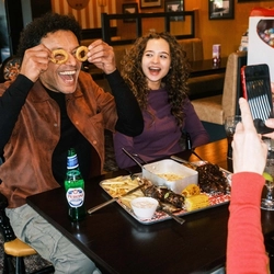 A family enjoying a meal and drinks in the interior restaurant from the new Spring/Summer menu at Flaming Grill.