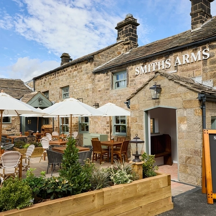 The exterior facade, signage, and beer garden seating area of the Smiths Arms pub in Beckwithshaw.