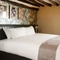 A bed in a hotel room of The Narborough Arms.