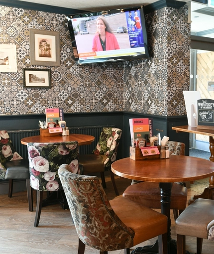 Interior dining area of a pub with a TV.