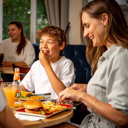 A family sat at an indoor table enjoying a meal and drinks at a Hungry Horse venue.