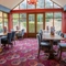 The interior restaurant seating area in the conservatory of The Royal Horse in Warwick, with wooden tables and upholstered seats.