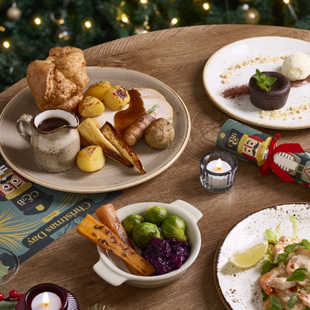 A banner showing several Festive Spread dishes sat on a table within the interior restaurant seating area at a Chef & Brewer venue.