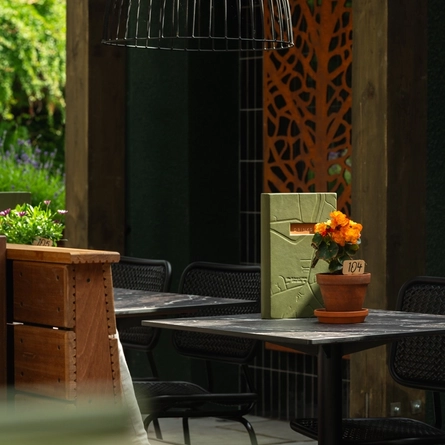 Exterior walled beer garden seating area under a wooden veranda at the rear of the Prince Of Wales.