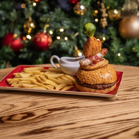 A plated Festive Burger on a wooden table.