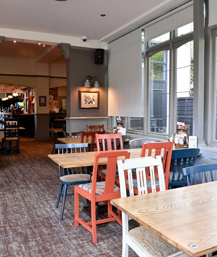 Interior dining area of a pub with a TV.