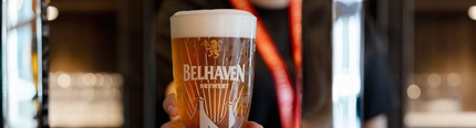 An image of a member of the bar staff placing a pint of Belhaven Belter on the interior bar.