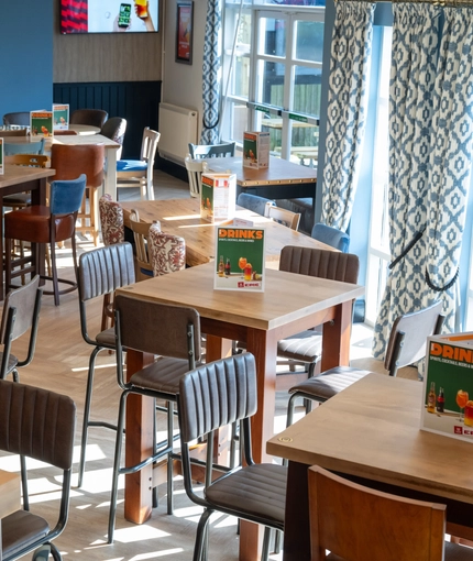 The interior restaurant and seating area with TV at the Woodlands Edge.