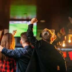 Friends watch football on the TV in a pub