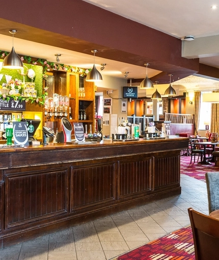 Interior dining area of a pub with a bar.