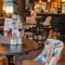 The bar and interior restaurant seating area at The Carousel, with wooden tables, upholstered seats, and TVs on the walls.