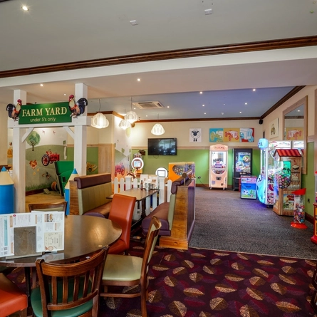 Internal dining area of a pub with a play area.