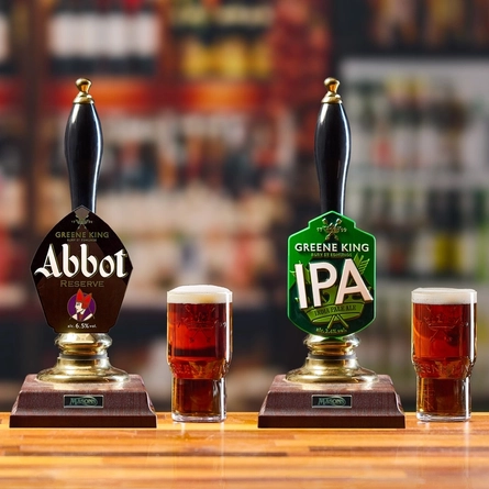 An image of an interior bar with a pint of Abbot Reserve next to an Abbot Reserve pump and a pint of Greene King IPA next to a Greene King IPA pump.