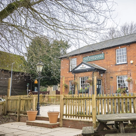 An exterior shot of the venue entrance, facade, beer garden and signage at the Chequers in Streatley.