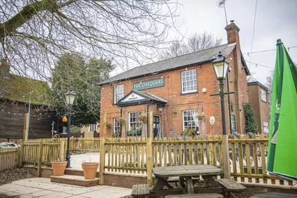 An exterior shot of the venue entrance, facade, beer garden and signage at the Chequers in Streatley.