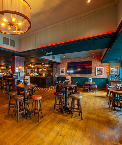 The bar and interior restaurant seating area at the Scholars Arms; with a TV on the wall.