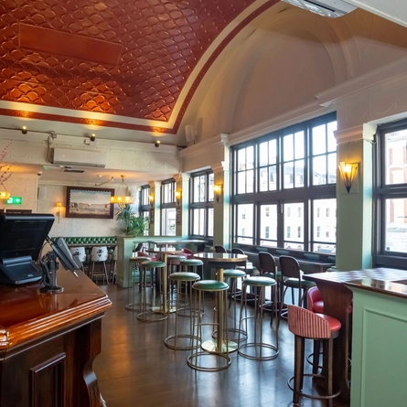 Interior of bar with high tables and bar stools surrounding