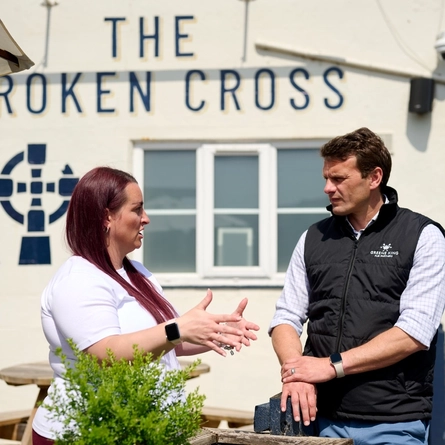 An image showing 2 people stood within the exterior beer garden seating area, talking for Pub Partners.