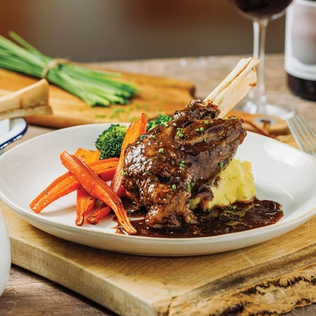 a plate of Sunday roast sitting on a wooden table of a pub