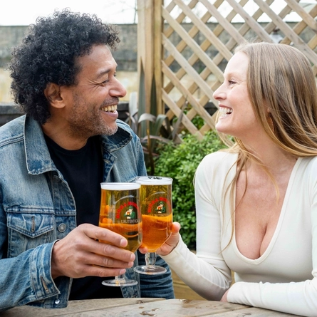 Two people enjoying a drink in a beer garden.
