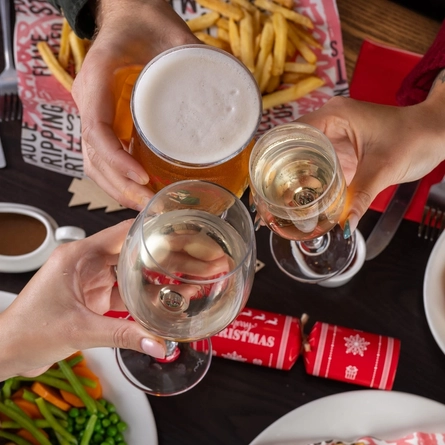 plates of food and a few drinks sitting on a wooden table of a pub
