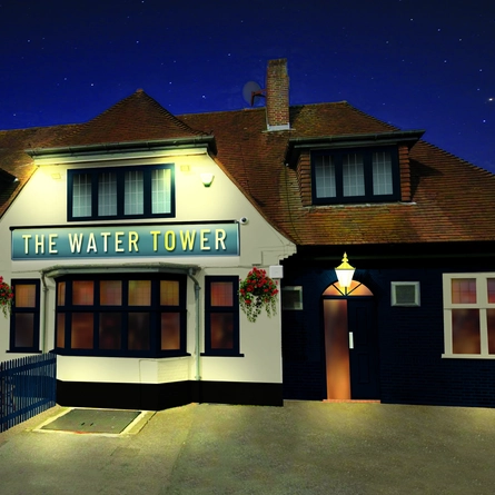 The exterior facade lit up during the evening with outdoor seating area at The Water Tower.