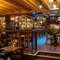 The bar and interior restaurant seating area of the Old School House, with wood panelling on the walls, and TVs above the bar.