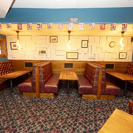 Interior dining area of a pub with TV screens.