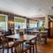 An interior restaurant seating area at The Walkford, with wooden beams on the ceiling, and leaded windows.