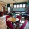 An interior restaurant seating area at the Golden Hind, with two dartboards, and upholstered chairs and bench seating.