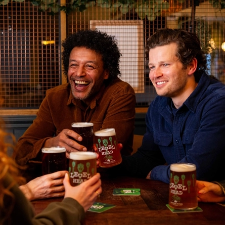 A group of people enjoying a beer at a table.