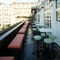 Exterior balcony seating area, with tall tables and bar stools