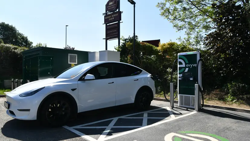 A car charging at an EV charger in a car park.
