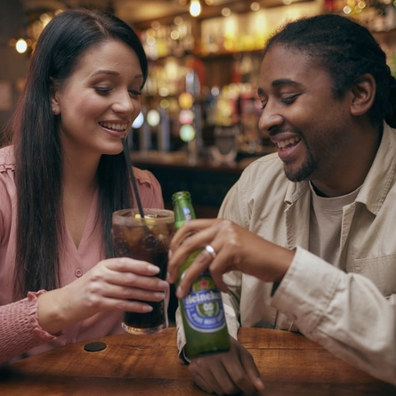 Two people cheersing drinks