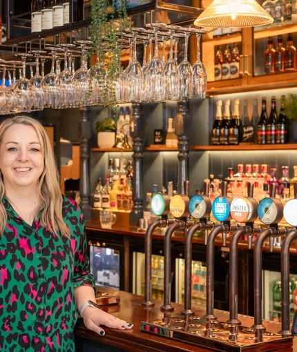 The General Manager of the Prince Of Wales standing in front of the bar.